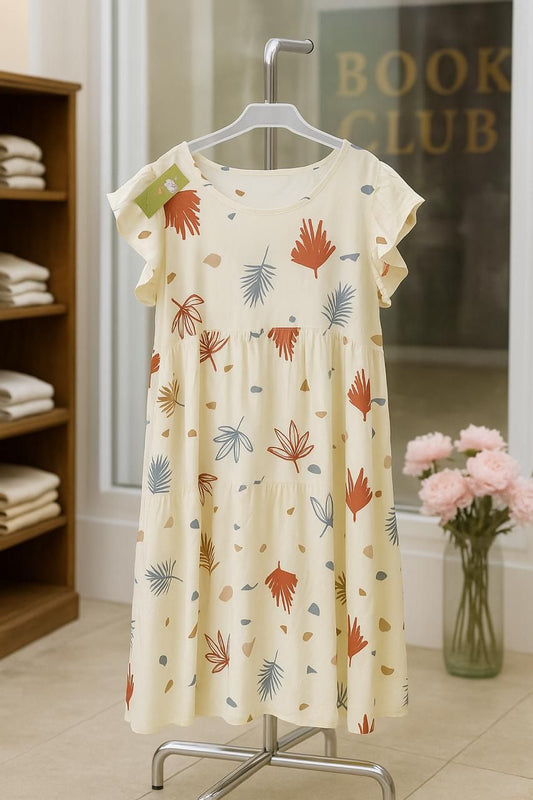 Dress with floral pattern on a hanger in a room with a bookshelf and flowers.