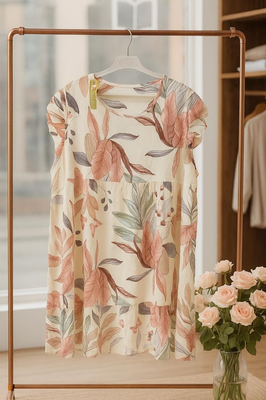 Cream floral dress on a hanger with a blurred background