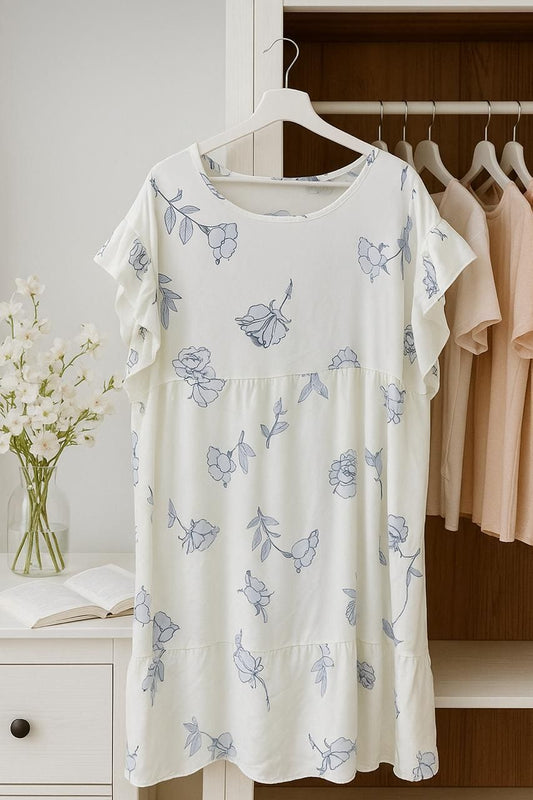 Floral patterned dress on a hanger in a room with wooden shelves and flowers.