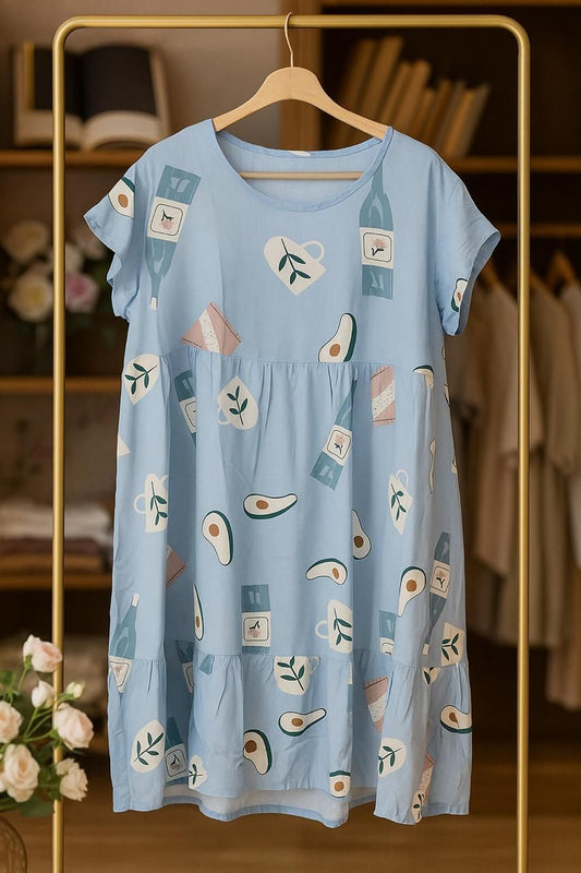 Light blue dress with avocado print on a hanger against a blurred background