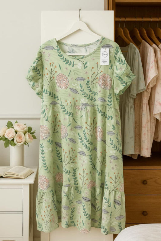 Green floral dress hanging on a rack with a white background